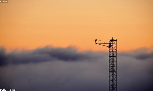 A small automated weather station on a foggy hillside