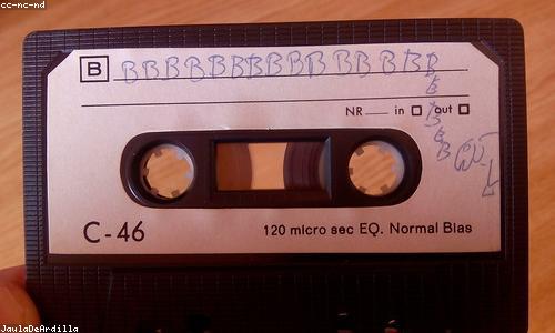A cassette tape being labeled by hand