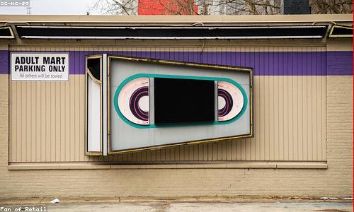A neon-lit video rental store front, still open after midnight